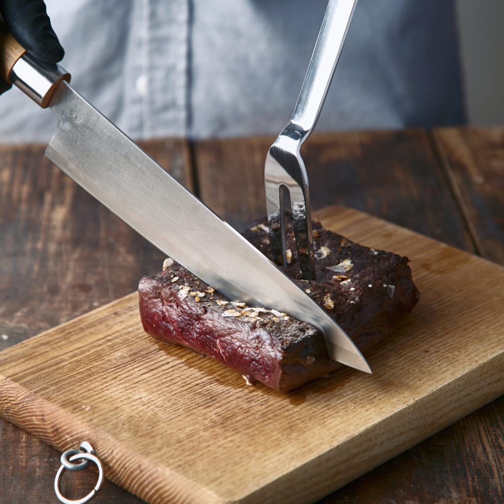 Hands cut medium rare cooked whale meat steak